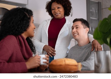 Cheerful brazilian multigenerational family in breakfast spending time together in kitchen home, indoors. Relationship, leisure, enjoyment, concept. - Powered by Shutterstock