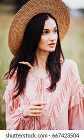 Cheerful brunette woman in pink dress and hay hat - Shutterstock ID 667423504