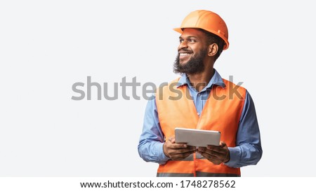 Cheerful Builder Holding Digital Tablet Smiling Looking Aside Posing On White Studio Background. Free Space, Panorama