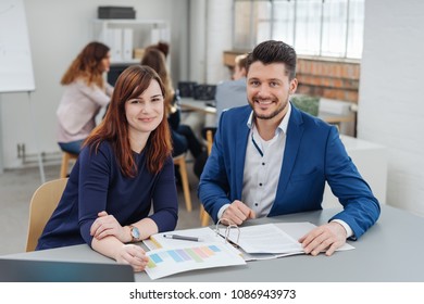 Cheerful business coworkers discussing on project in office