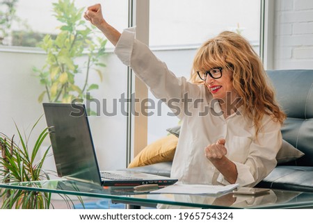 cheerful business woman at desk with computer excited