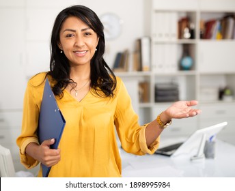 Cheerful business woman in light office holding clipboard with papers document write notes - Shutterstock ID 1898995984