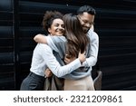 Cheerful businessman and businesswomen hugging each other in front of office building. Colleagues hug colleague who change her job and work, going to another company.