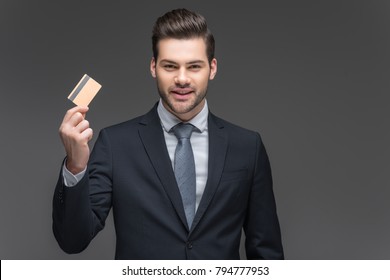 Cheerful Businessman Holding Credit Card, Isolated On Grey