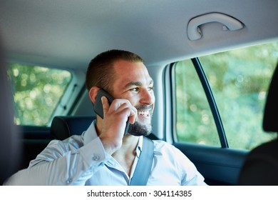 Cheerful Businessman With A Phone In Car