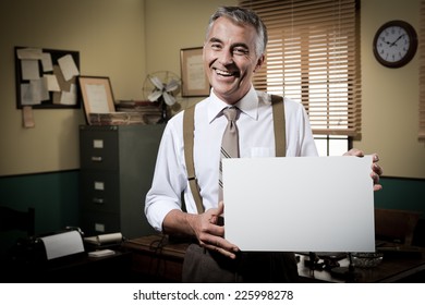 Cheerful Businessman Showing A Blank Sign And Smiling, 1950s Office On Background.