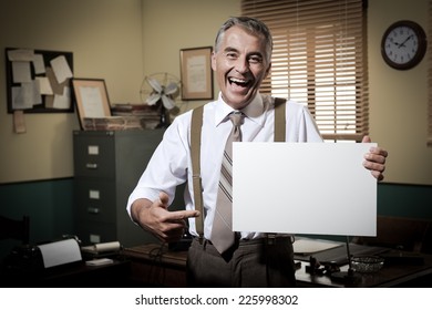 Cheerful Businessman Showing A Blank Sign And Smiling, 1950s Office On Background.