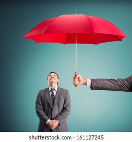 Cheerful businessman under an umbrella
