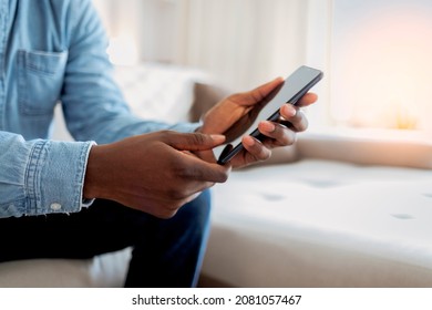 Cheerful Businessman Using Smartphone While Sitting On Sofa At Home. Closeup Of Mature Black Man Using Smartphone To Checking Email At Home. Happy African American Man Using Phone Mobile At Home.