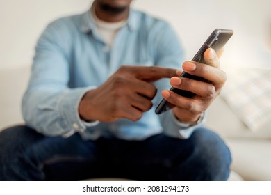 Cheerful Businessman Using Smartphone While Sitting On Sofa At Home. Closeup Of Mature Black Man Using Smartphone To Checking Email At Home. Happy African American Man Using Phone Mobile At Home.