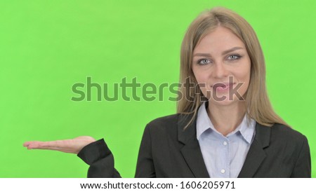 Cheerful Businesswoman Showing open Hand Palm against Chroma Key