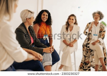 Cheerful businesswomen having a discussion during a conference meeting in a modern workplace. Group of multicultural businesswomen working together in an all-female startup.