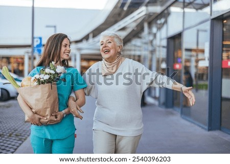 A cheerful caregiver helps a joyful elderly woman with groceries. The scene captures warmth, companionship, and supportive care in an outdoor shopping environment.