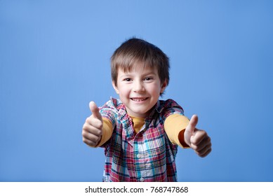 Cheerful Caucasian boy is holding thumbs up and smiling in the camera. - Shutterstock ID 768747868