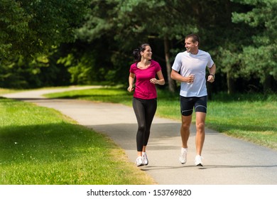Cheerful Caucasian couple friends running in park - Shutterstock ID 153769820