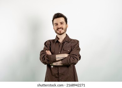 Cheerful Caucasian Man Wearing Brown Shirt Posing Isolated Over White Background Smiling With Crossed Arms Looking At The Camera. Positive Person.