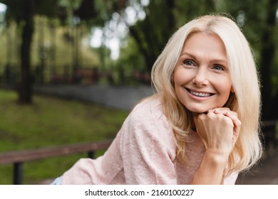 Cheerful Caucasian Mature Blonde Woman Wife With Toothy Smile Relaxing Resting Walking In City Park Forest Alone Outdoors