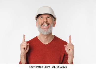 Cheerful Caucasian Mature Middle-aged Man Construction Worker Builder Architect Engineer In Protective Hard Hat Pointing Upwards At Copy Space Isolated In White Background