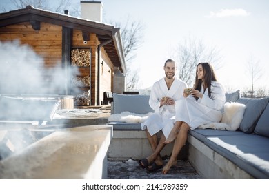 Cheerful Caucasian Young Romantic Couple Friends Relaxing Together, Share Impressions After Work Week, Social Networks, Watch Webinar Online Outdoors In City Park