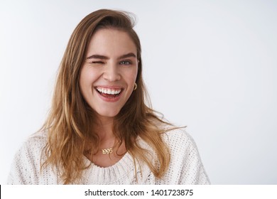 Cheerful charming bright caucasian woman 25s short chestnut hair winking joyfully smiling broadly white teeth, having fun enjoying spring time positive vibes, standing happily studio background - Shutterstock ID 1401723875