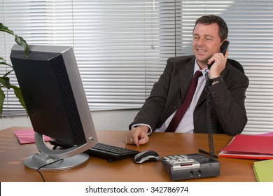 Cheerful And Charming Man In Office Answering The Phone