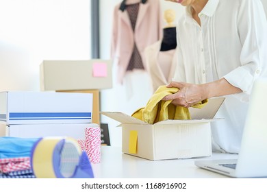 Cheerful charming young business owner standing in clothing shop - Shutterstock ID 1168916902