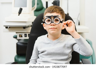 Cheerful Child Boy In Glasses Checks Eye Vision Pediatric Ophthalmologist.