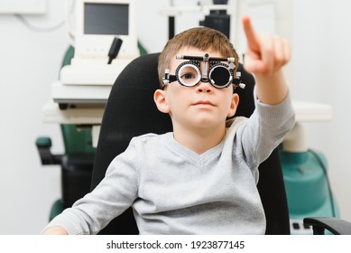 Cheerful Child Boy In Glasses Checks Eye Vision Pediatric Ophthalmologist.