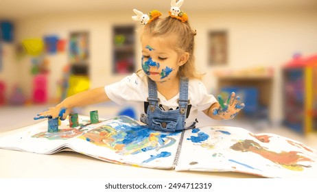 Cheerful Child Creating Art with Finger Paints - Little Girl Enjoying a Finger Painting Session - Powered by Shutterstock