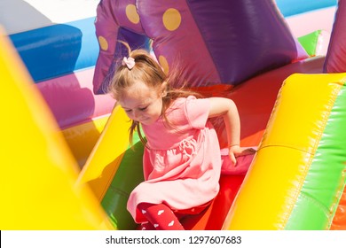 A cheerful child plays in an inflatable castle - Shutterstock ID 1297607683