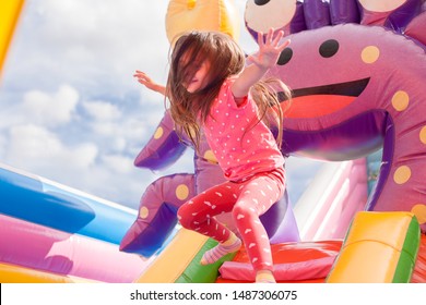 A cheerful child plays in an inflatable castle - Shutterstock ID 1487306075