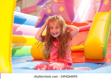 A cheerful child plays in an inflatable castle - Shutterstock ID 1494264095