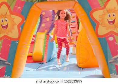 A cheerful child plays in an inflatable castle - Shutterstock ID 1522333979
