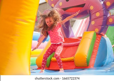 A cheerful child plays in an inflatable castle - Shutterstock ID 1665722374