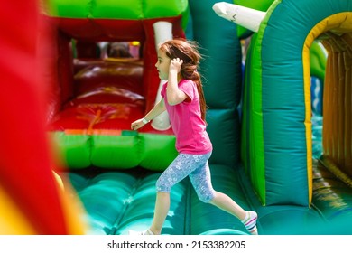 A cheerful child plays in an inflatable castle - Shutterstock ID 2153382205