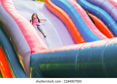 A cheerful child plays in an inflatable castle - Shutterstock ID 2184007003