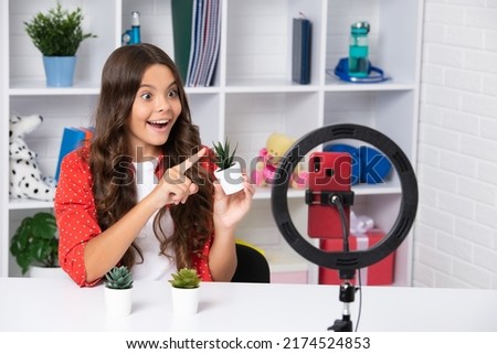 Cheerful child vlogger making video blog on phone. Blogging weblog and vlog. Teen girl blogger influencer recording video for social media. Excited face, cheerful emotions of teenager girl.