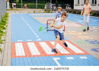 Cheerful children play hockey in the school yard. Summer. - Powered by Shutterstock