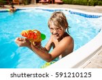 Cheerful children playing waterguns, rejoicing, jumping, swimming in pool.
