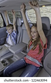 Cheerful Children Sitting At Back Seat Of Car