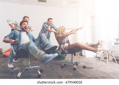 Cheerful Colleagues Having Fun In Office Chairs