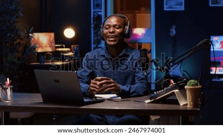 Cheerful content creator using outlined ideas on notebook to film vlog channel intro for online streaming platforms. Happy man following discourse script on paper, presenting vlogging topic