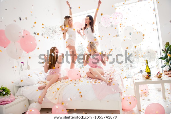 Cheerful, cool, sexy,
pretty, charming, funky girls in night wear enjoying rain of
colorful stars, confetti having theme party meeting indoor,
drinking alcohol, dancing,
laughing
