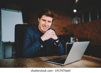 Cheerful Corporate Employer Using Laptop Computer During Working Time In Office Interior, Portrait Of Successful Businessman Smiling At Camera Sitting At Desktop With Modern Netbook Technology