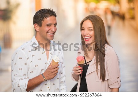Cheerful couple eating ice cream cones