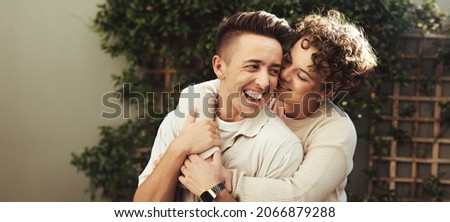 Cheerful couple embracing each other outdoors. Happy young queer couple smiling cheerfully while standing together during the day. Young LGBTQ+ couple spending quality time together. Foto stock © 
