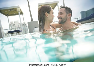 Cheerful couple enjoying bath in resort swimming pool - Powered by Shutterstock
