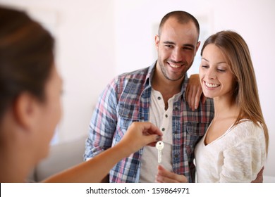 Cheerful Couple Getting Keys Of Their New Home