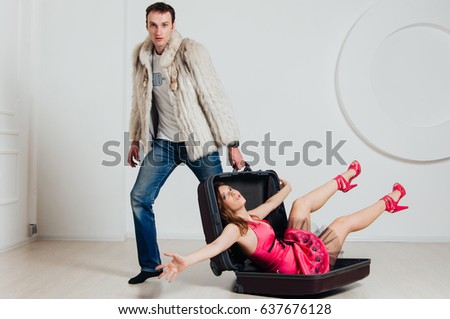 Cheerful couple going on a trip. Man in a fur coat