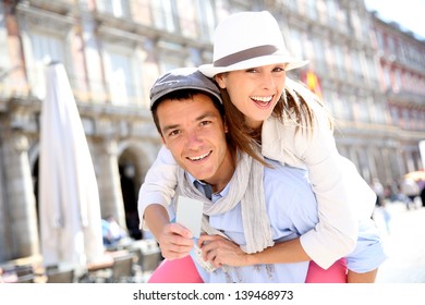 Cheerful Couple Holding Visitor Pass Of Madrid Capital